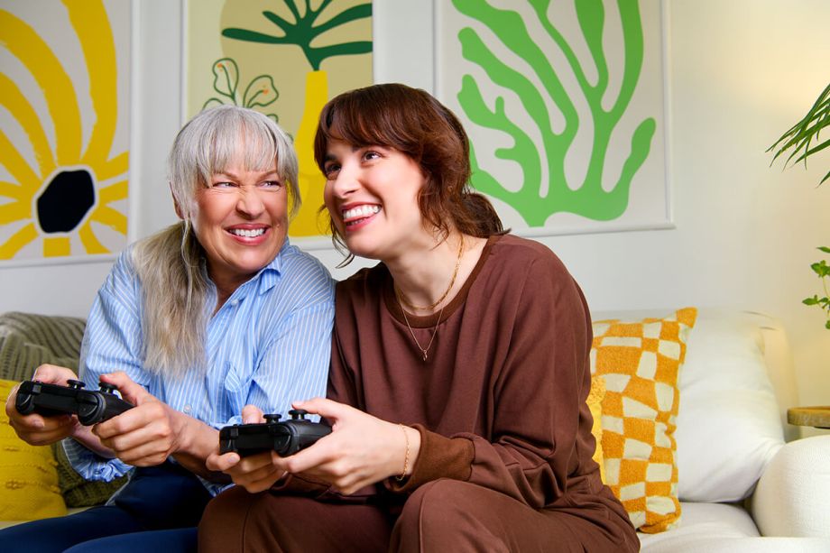 Grandmother and grand daughter playing video games together